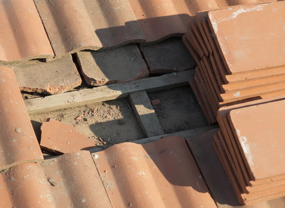 Tuiles plates cassées à remplacer lors d’une réparation de toiture près de Laon